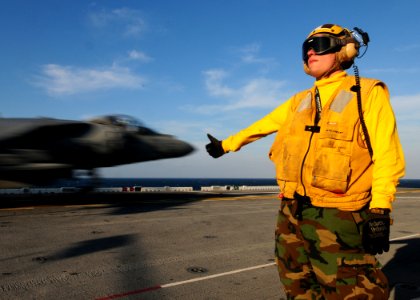 US Navy 110202-N-5538K-097 Aviation Boatswain's Mate Airman Jeremy J. New gives the okay signal as an AV-8B Harrier jet aircraft photo