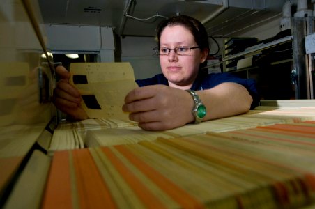 US Navy 110203-N-7488A-029 Electrician's Mate 2nd Class Katie McPherson checks for validation cards