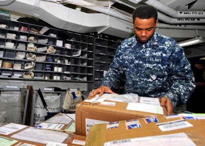 US Navy 110129-N-0569K-058 Logistics Specialist 2nd Class Joe Pankey, the ship's post office work center supervisor, verifies a customer address fo