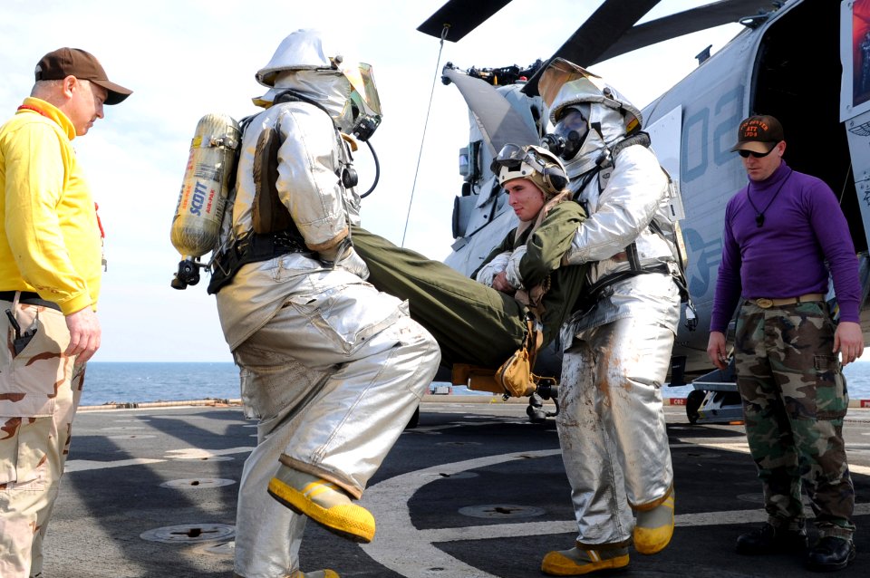 US Navy 110202-N-6692A-043 Sailors carry an injured Marine pilot from a simulated downed helicopter