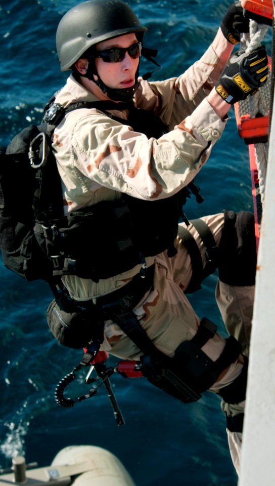 US Navy 110128-N-9589S-190 Sonar Technician 2nd Class Curtis M. Macner descends into a rigid-hull inflatable boat during a training exercise aboard
