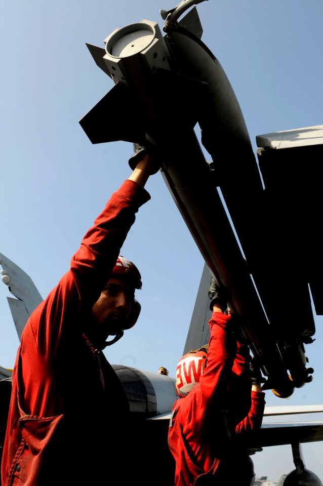 US Navy 110203-N-8040H-205 Aviation Ordnanceman 2nd Class Garland Cross loads an AIM-9X Sidewinder air-to-air missile on an F-A-18C Hornet aboard U