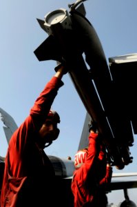 US Navy 110203-N-8040H-205 Aviation Ordnanceman 2nd Class Garland Cross loads an AIM-9X Sidewinder air-to-air missile on an F-A-18C Hornet aboard U