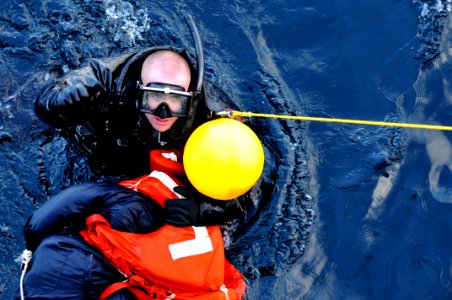 US Navy 110203-N-9818V-325 Search and rescue swimmer Seaman Matthew Honan gives the thumbs up to be taken out of the water after rescuing Oscar