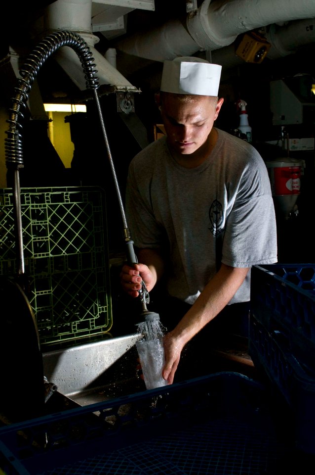 US Navy 110130-N-7488A-004 Aviation Ordnanceman Airman Johnny-Ryan Jansen washes dishes in the scullery aboard the Nimitz-class aircraft carrier US