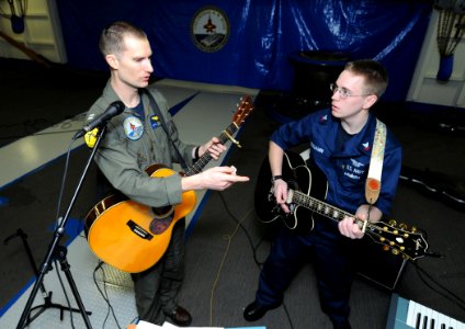 US Navy 110130-N-6632S-009 Lt. Matt Thien instructs Aviation Electrician's Mate 2nd Class Keith Benjamin during a warm-up for a church service aboa