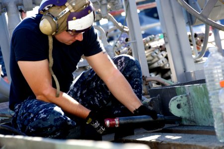 US Navy 110127-N-9643K-379 A Sailor assigned to the amphibious assault ship USS Bonhomme Richard (LHD 6) uses a needle gun to strip paint from a fi