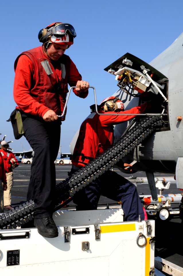 US Navy 110201-N-8040H-331 Aviation Ordnanceman 2nd Class Nickelous Burgess, left, and Aviation Ordnanceman 2nd Class Keaton Smith load 20 mm ammun