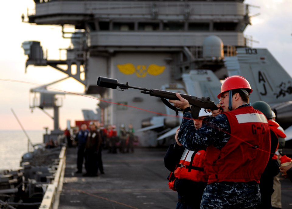 US Navy 110130-N-3374C-083 A Sailor from the weapons department aboard the aircraft carrier USS George H.W. Bush (CVN 77) fires a shot line to the