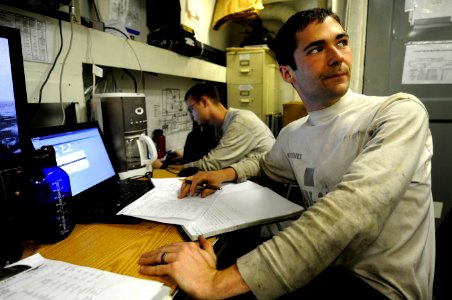 US Navy 110205-N-8040H-065 Aviation Machinist's Mate 1st Class Patrick Sohnly logs turnover information aboard USS Carl Vinson (CVN 70)