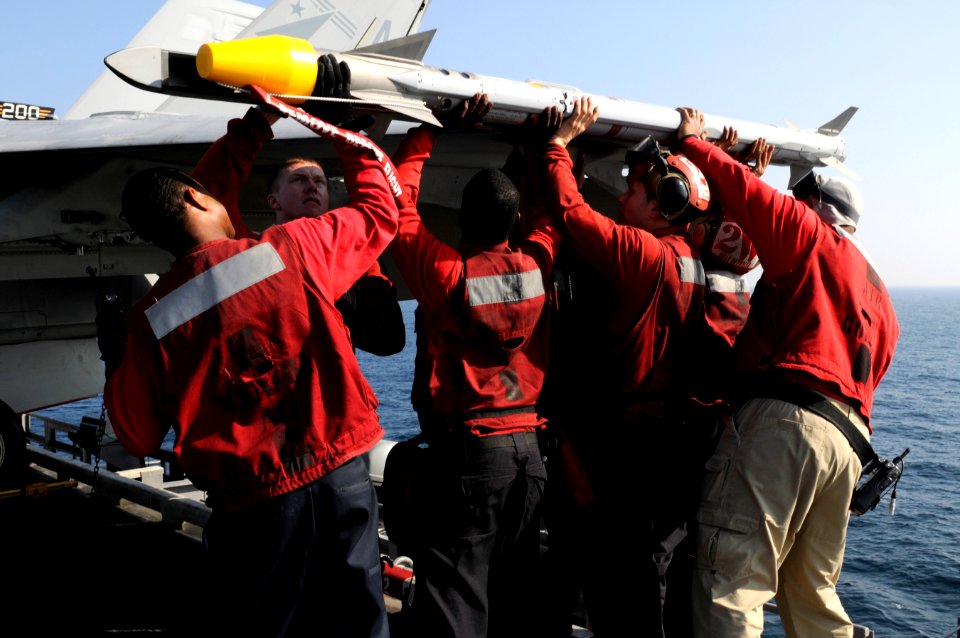 US Navy 110201-N-8040H-382 Sailors assigned to Strike Fighter Squadron (VFA) 81 load an AIM-9X Sidewinder air-to-air missile onto an F-A-18E Super