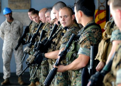 US Navy 110202-N-4743B-043 Marines check their weapons during a call-away drill in the hangar bay of USS Essex (LHD 2)