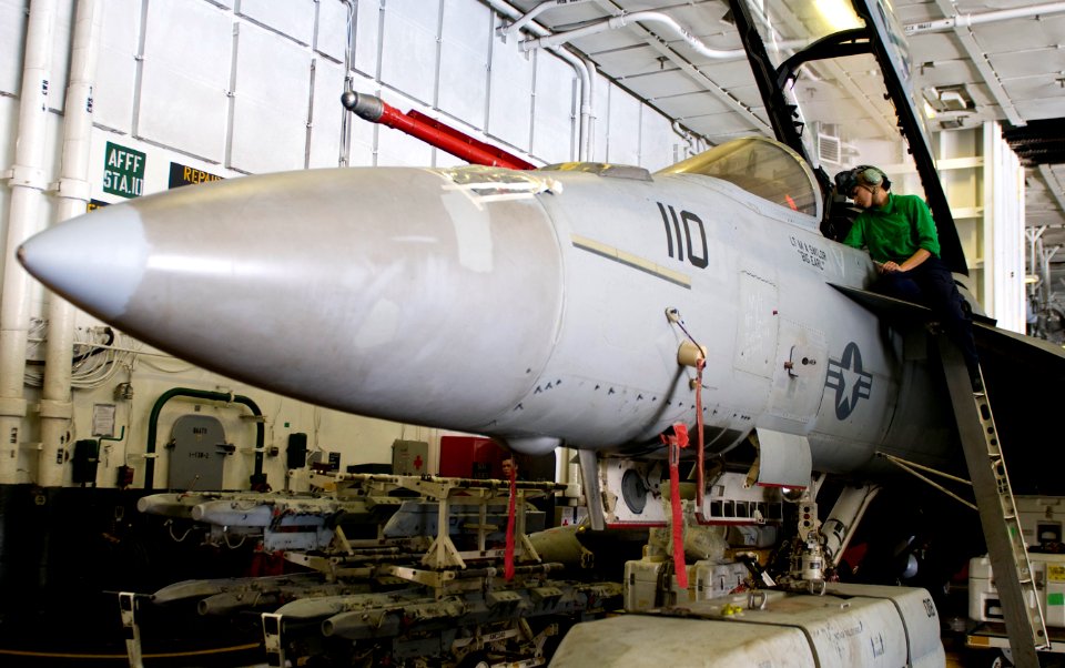 US Navy 110131-N-7488A-217 Aviation Electrician's Mate 2nd Class Amanda Mondino performs maintenance on an F-A-18F Super Hornet in the hangar bay a