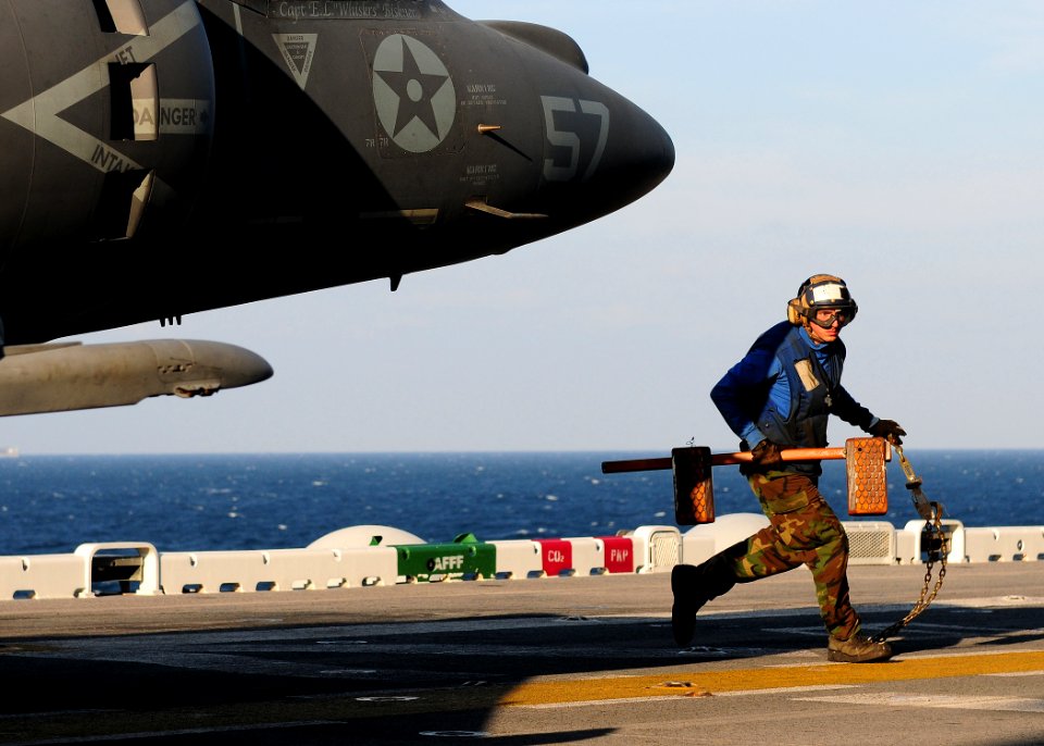 US Navy 110202-N-5538K-051 Aviation Boatswain's Mate Airman Heath R. Johnson removes a grounding gear from an AV-8B Harrier jet aircraft