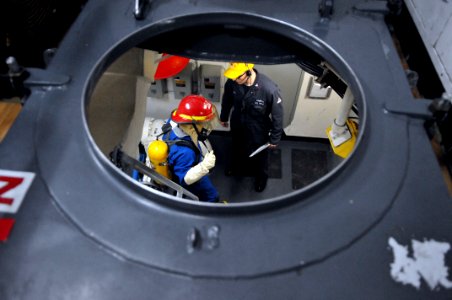 US Navy 110202-N-9818V-128 Damage Controlman 1st Class Branden Hudley evaluates a member of the fire party during a main space fire drill aboard US