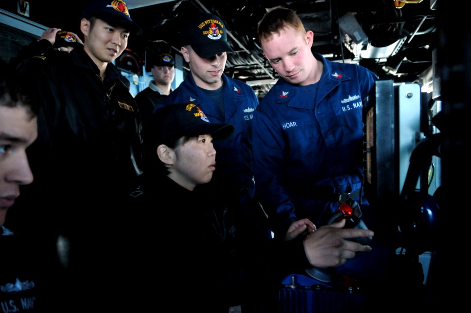 US Navy 110203-N-9818V-131 Japan Maritime Self-Defense Force Signalman 3rd Class Rika Okubo is given training by Gunner's Mate 1st Class Michael Ho