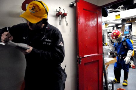 US Navy 110202-N-9818V-139 Damage Controlman 1st Class Branden Hudley evaluates Logistics Specialist 2nd Class Edgar Andres after boundaries are se