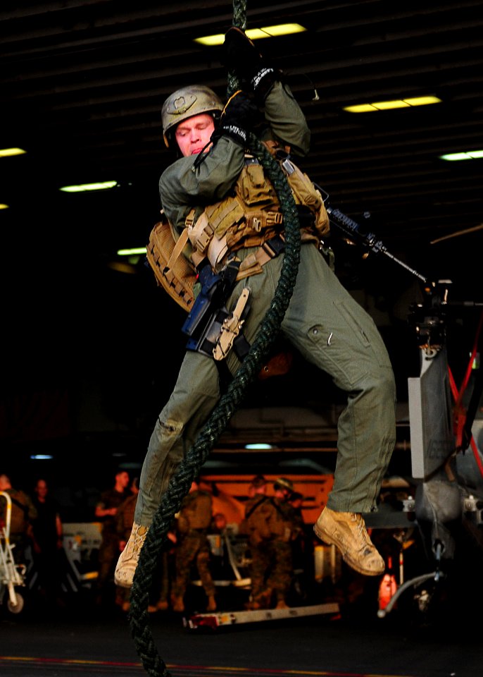 US Navy 110204-N-5538K-078 Hospital Corpsman 2nd Class Eric C. Haymes fast ropes onto the port aircraft elevator of USS Essex (LHD 2)