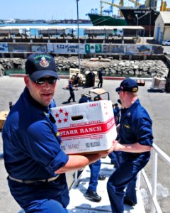 US Navy 110210-N-9811S-097 Chief Operations Specialist Jerome Hormuth passes a box during an all-hands working party aboard the Arleigh Burke-class