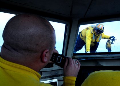 US Navy 110205-N-3178C-013 Lt. Bryan Bennett, left, and Aviation Boatswain's Mate (Handling) 1st Class Joe Flores ommunicate during flight operatio