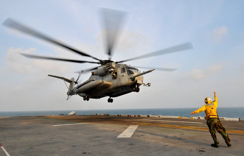 US Navy 110205-N-9950J-104 Aviation Boatswain's Mate (Handling) Airman Daniel Tesauro directs the landing of a CH-53E Sea Stallion helicopter aboar