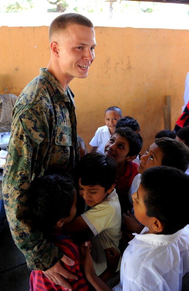 US Navy 110204-N-7589W-216 Lance Cpl. Paul Fuit hugs students at Escuela Campamento LaBarrita during a project completion ceremony at the school in