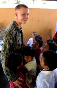 US Navy 110204-N-7589W-216 Lance Cpl. Paul Fuit hugs students at Escuela Campamento LaBarrita during a project completion ceremony at the school in