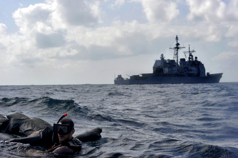 US Navy 110211-N-6006S-066 Seaman Nicholas Mayer, a search and rescue swimmer aboard the guided-missile cruiser USS Bunker Hill (CG 52), in backgro