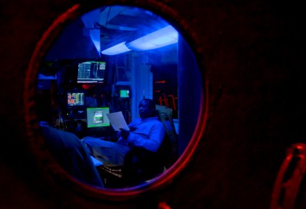 US Navy 110205-N-7981E-346 Lt. Cmdr. Tommy Edgeworth reviews flight schedules aboard USS Carl Vinson (CVN 70)