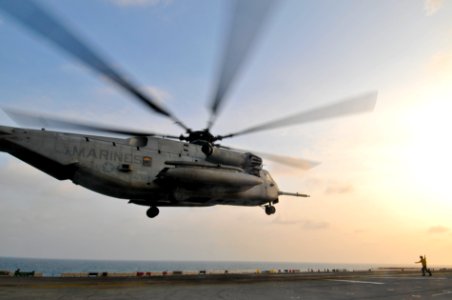 US Navy 110205-N-9950J-210 Aviation Boatswain's Mate (Handling) Airman Daniel Tesauro directs a CH-53E Sea Stallion helicopter as it lifts off aboa
