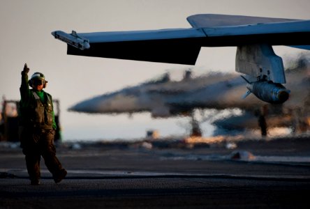 US Navy 110208-N-7981E-042 Aviation Boatswain's Mate (Equipment) Airman Rogello Gonzales signals for an F-A-18C Hornet to move forward from the arr