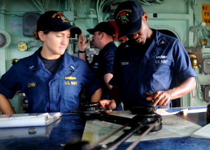 US Navy 110209-N-6692A-054 Lt. j.g. Brittany Lynn and Quartermaster 3rd Class Frederick Morgan work on a navigational chart aboard the amphibious t
