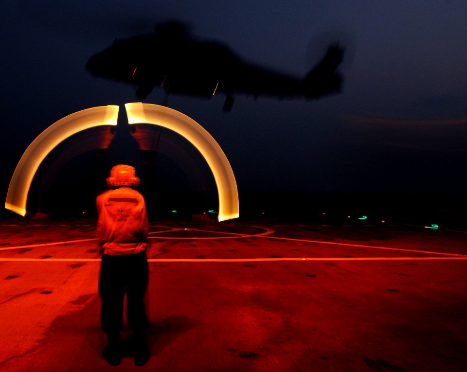 US Navy 110209-N-0864H-813 Culinary Specialist 3rd Class Drew Iverson directs an SH-60F Sea Hawk helicopter to take off from the U.S. 7th Fleet com
