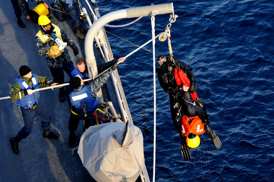 US Navy 110209-N-9818V-224 Information Systems Technician 3rd Class Benjamin Hodgkiss is taken out of the water after rescuing Oscar, a man overboa