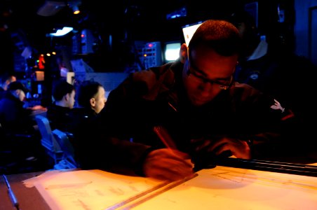 US Navy 110209-N-9094S-020 Operations Specialist 3rd Class Eric Castillo plots course markings on a digital dead reckoning tracer in the combat inf
