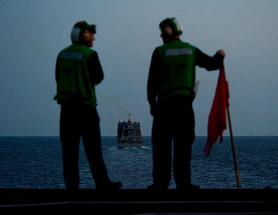 US Navy 110210-N-7981E-172 Quartermaster 2nd Class Matthew Trujillo, left, and Quartermaster Seaman Jacob Williams, wait to signal during a repleni