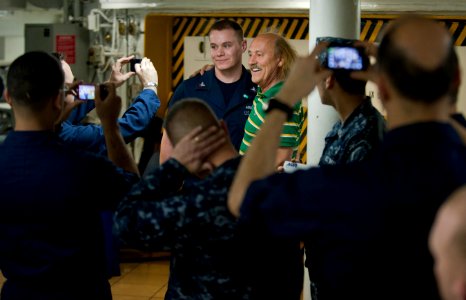 US Navy 110211-N-7981E-070 Comedian Gallagher poses with Sailors during an autograph signing on the mess decks of the Nimitz-class aircraft carrier