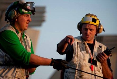 US Navy 110210-N-7981E-389 Boatswain's Mate 1st Class Robert Huxoll directs line handlers on the flight deck of the Nimitz-class aircraft carrier U