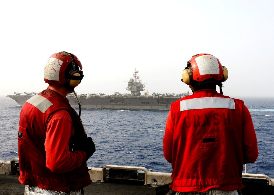 US Navy 110216-N-2908M-073 Sailors watch the aircraft carrier USS Enterprise (CVN 65) from aboard the amphibious assault ship USS Kearsarge (LHD 3)