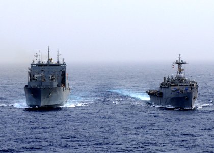 US Navy 110216-N-3154P-426 The amphibious transport dock ship USS Ponce (LPD 15), right, is underway alongside the Military Sealift Command dry car