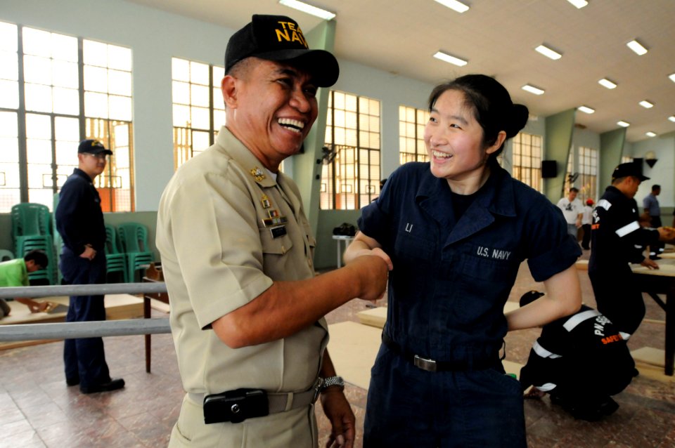 US Navy 110215-N-9094S-076 Machinist's Mate Fireman Man Li shakes hands with Republic of the Philippines navy Chief Petty Officer Pablo Bauit durin