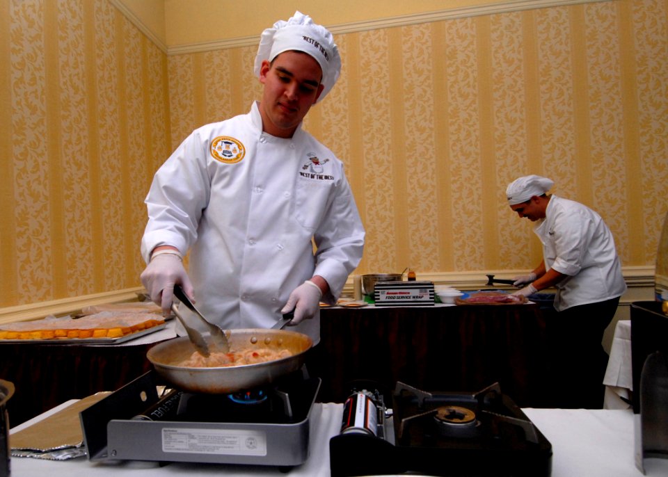 US Navy 110211-N-NK458-022 Culinary Specialist 3rd Class Alonso Galdamez sautees shrimp during the Best of the Mess Challenge competition at the Vi