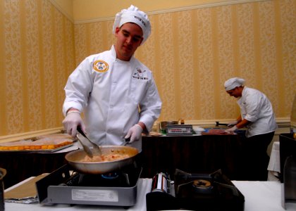 US Navy 110211-N-NK458-022 Culinary Specialist 3rd Class Alonso Galdamez sautees shrimp during the Best of the Mess Challenge competition at the Vi
