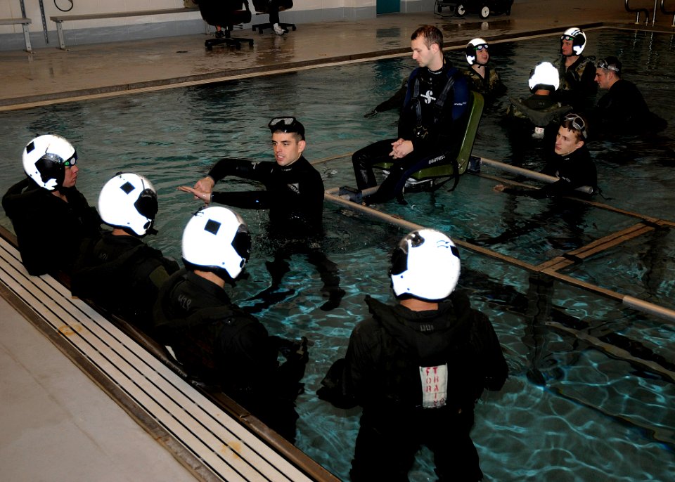 US Navy 110215-N-ZK021-001 Sailors listen as Hospital Corpsman 3rd Class Sean Kelly demonstrates a proper clean sweep before exiting an aircraft