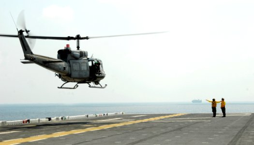 US Navy 110213-N-8607R-497 A UH-1N Huey helicopter lands aboard the forward-deployed amphibious assault ship USS Essex (LHD 2) photo