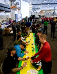 US Navy 110216-N-DR144-115 Members of the Green Bay Packers football team sign autographs for Sailors in the hangar bay aboard the aircraft carrier