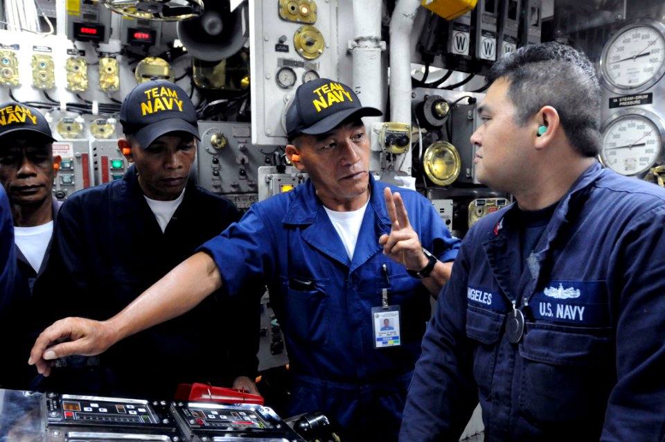 US Navy 110214-N-9094S-110 Machinist's Mate 2nd Class Pierre Angeles speaks with Republic of the Philippines navy sailors about boiler console oper