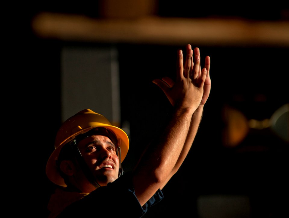 US Navy 110217-N-DR144-180 Boatswain's Mate 2nd Class Zachary Chavez signals as pallets of stores arrive in the hangar bay of USS Carl Vinson (CVN