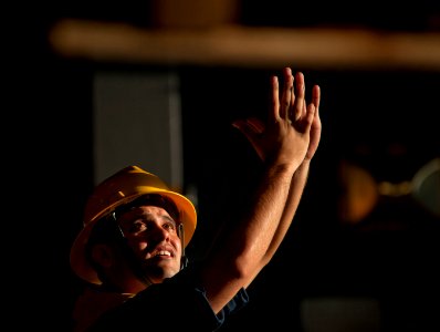 US Navy 110217-N-DR144-180 Boatswain's Mate 2nd Class Zachary Chavez signals as pallets of stores arrive in the hangar bay of USS Carl Vinson (CVN