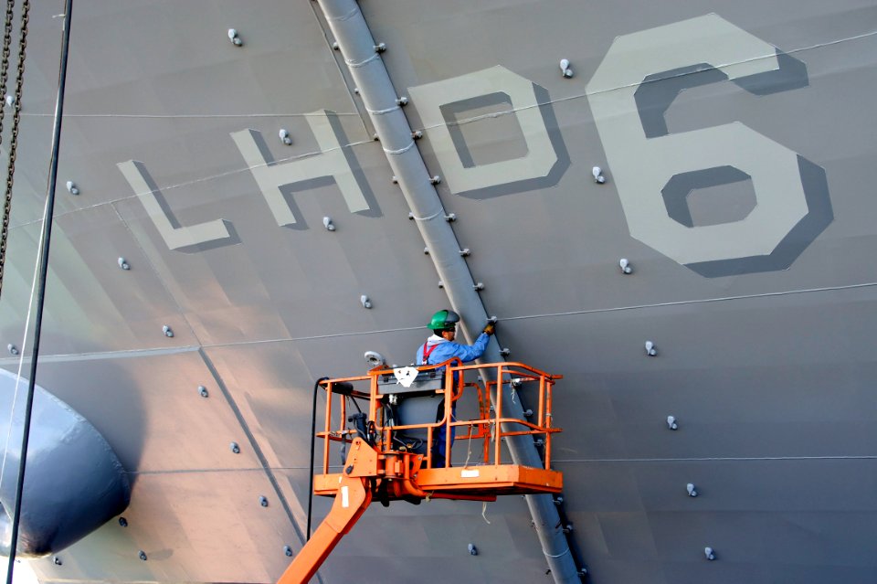 US Navy 110217-N-ZC343-937 A shipyard worker from National Steel and Shipbuilding Company reattaches a funnel drain to the port side of the amphibi